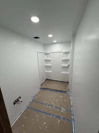 Walk-in closet with white drywall, built-in shelving, and recessed LED lighting